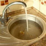 clogged kitchen sink with food waste