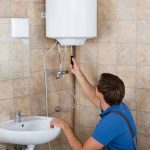 plumber repairing traditional water heater