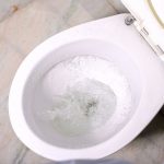 Close up flushing water in clean toilet bowl