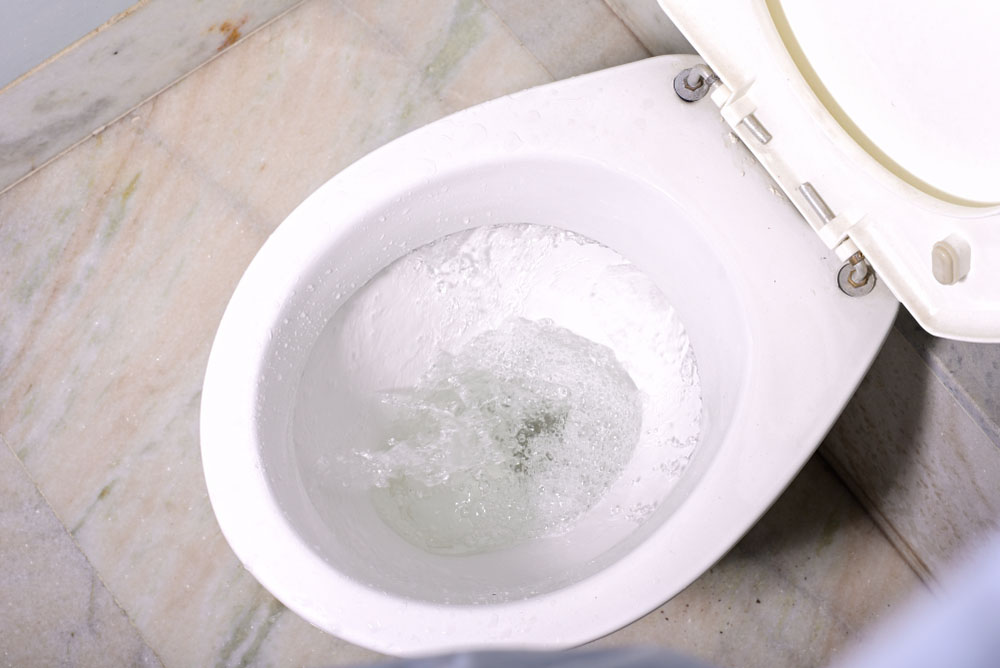 Close up flushing water in clean toilet bowl