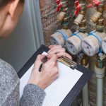 Woman checking the readout on a water meter plumbing