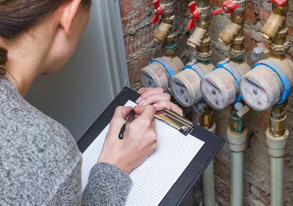 Woman checking the readout on a water meter plumbing