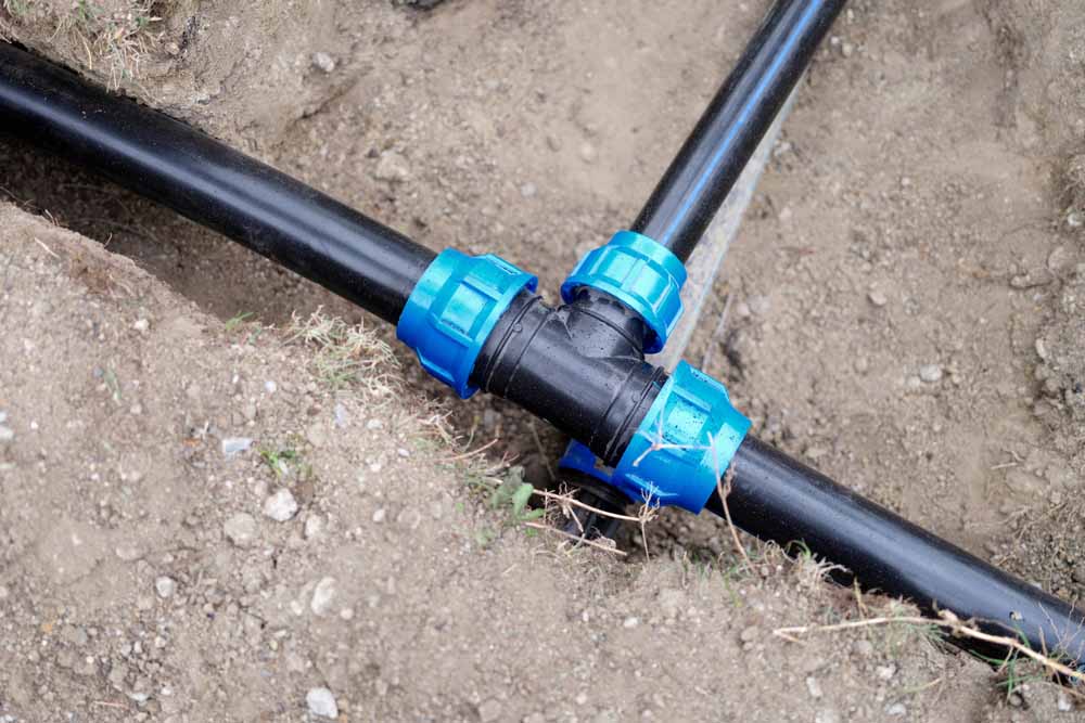 Equipment for automatic watering soil pipes lying in ground closeup. Plumbing work concept